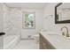 Modern bathroom features tiled shower and floor, window, and beautiful vanity with gold faucet at 8246 Windcombe Blvd, Indianapolis, IN 46240
