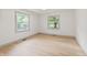 Bright bedroom featuring hardwood floors, natural light from two windows, and neutral paint colors at 8246 Windcombe Blvd, Indianapolis, IN 46240