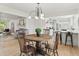 Open-concept dining area with a round table, adjacent to a modern kitchen and cozy living space at 8246 Windcombe Blvd, Indianapolis, IN 46240