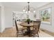 Elegant dining room with a round table, wooden chairs, and a serene view from the window at 8246 Windcombe Blvd, Indianapolis, IN 46240