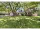 Charming one-story brick home featuring a well-manicured lawn and mature trees providing ample shade at 8246 Windcombe Blvd, Indianapolis, IN 46240