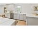 Bright kitchen featuring quartz countertops, stainless steel dishwasher, and grey cabinetry at 8246 Windcombe Blvd, Indianapolis, IN 46240