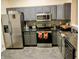 Well-equipped kitchen features sleek gray cabinets, stainless steel appliances, and dark countertops, offering modern functionality and style at 8333 Pine Branch Ln, Indianapolis, IN 46234
