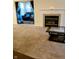 Living room featuring neutral carpet, fireplace and pass-through to the second Gathering room with black sofas at 8333 Pine Branch Ln, Indianapolis, IN 46234