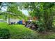 Landscaped backyard with play set, exterior building, and lush greenery on a partially cloudy day at 9042 Panorama Ct, Indianapolis, IN 46234