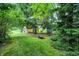 Wide backyard featuring a fire pit, exterior building, green lawn and mature trees at 9042 Panorama Ct, Indianapolis, IN 46234