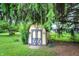 Backyard shed with double doors, surrounded by green grass and mature trees at 9042 Panorama Ct, Indianapolis, IN 46234