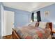 This bedroom has a large bed, hardwood floors, and blue walls at 9042 Panorama Ct, Indianapolis, IN 46234