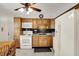 Traditional kitchen featuring light wood cabinets, white appliances, dark backsplash, and updated flooring at 9042 Panorama Ct, Indianapolis, IN 46234