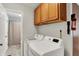 Well-lit laundry room features a washer and dryer, complemented by cabinetry for storage and a door to the bathroom at 9042 Panorama Ct, Indianapolis, IN 46234