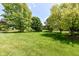 Expansive backyard with well-maintained green lawn and mature trees on a sunny day at 10005 Southwind Dr, Indianapolis, IN 46256