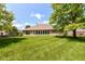 Lush green backyard featuring a well-kept lawn and mature trees, offering privacy at 10005 Southwind Dr, Indianapolis, IN 46256
