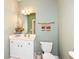 Neat half bathroom with white vanity, toilet, neutral paint and simple decor at 10005 Southwind Dr, Indianapolis, IN 46256