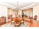 Open dining room with chandelier, hardwood floors, and views to other living areas at 10005 Southwind Dr, Indianapolis, IN 46256