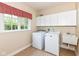 Functional laundry room features a washer, dryer, utility sink, and ample storage cabinets at 10005 Southwind Dr, Indianapolis, IN 46256