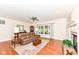 Comfortable living room with fireplace, hardwood floors, and natural light from large windows at 10005 Southwind Dr, Indianapolis, IN 46256