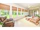 Bright sun room with multiple windows, brick wall, and multiple seating options at 10005 Southwind Dr, Indianapolis, IN 46256