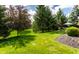 Lush backyard featuring well-maintained grass, mature trees, and beautiful landscaping at 10480 Stonegate Dr, Fishers, IN 46040
