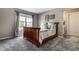 Bright bedroom with a wooden bed frame, soft carpet, and natural light from a window at 10480 Stonegate Dr, Fishers, IN 46040