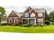 Inviting two-story brick home featuring manicured landscaping and a well-maintained lawn at 10480 Stonegate Dr, Fishers, IN 46040