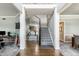 Spacious hallway with stairs and an open view, featuring hardwood and carpeted floors at 10480 Stonegate Dr, Fishers, IN 46040