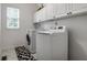 Laundry room with white cabinets, a window and a washer and dryer at 10480 Stonegate Dr, Fishers, IN 46040