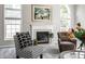 Cozy living room with a fireplace, comfortable seating, and bright, large windows at 10480 Stonegate Dr, Fishers, IN 46040