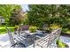 Outdoor patio featuring comfortable seating, floral arrangements, and mature trees at 10480 Stonegate Dr, Fishers, IN 46040