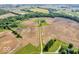 Expansive aerial view showcasing a stately home surrounded by sprawling farmland and tree-lined boundaries at 10705 N State Road 267, Brownsburg, IN 46112