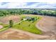 Aerial view of the property with a long driveway and surrounded by plowed fields and greenery at 10705 N State Road 267, Brownsburg, IN 46112