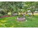 Serene backyard featuring a brick fire pit, picnic table, and lush landscaping at 10705 N State Road 267, Brownsburg, IN 46112
