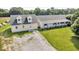 Aerial view of a light yellow home with well-manicured lawn and gravel driveway at 10705 N State Road 267, Brownsburg, IN 46112