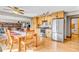Open-concept kitchen with wood cabinets, stainless steel refrigerator, and hardwood flooring at 10705 N State Road 267, Brownsburg, IN 46112