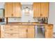 Bright kitchen showcasing light wood cabinetry, stainless steel dishwasher, and modern fixtures at 10705 N State Road 267, Brownsburg, IN 46112