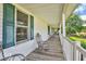 Relaxing side porch featuring rocking chairs and a view of the landscaped backyard at 10705 N State Road 267, Brownsburg, IN 46112