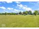 Expansive grassy yard with mature trees and a charming play area, perfect for outdoor activities at 10705 N State Road 267, Brownsburg, IN 46112