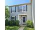 The front exterior of this home features well-maintained landscaping, complemented by gray siding and dark shutters at 10775 Cyrus Dr, Indianapolis, IN 46231