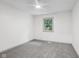 Bright bedroom features neutral carpet, ceiling fan, and a window overlooking the outdoors at 10778 Haverstick Rd, Carmel, IN 46033