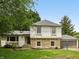 Charming two-story home featuring stone accents, neutral siding, lush lawn, and attached garage at 10778 Haverstick Rd, Carmel, IN 46033