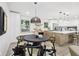 Eat-in kitchen featuring modern black chairs, pendant lighting, and white cabinets in a bright, airy space at 10778 Haverstick Rd, Carmel, IN 46033