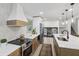 Stylish kitchen with stainless steel appliances, range hood, light wood cabinets, and quartz countertops at 10778 Haverstick Rd, Carmel, IN 46033