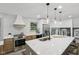 Modern kitchen with stainless steel appliances, a large island with white countertops, and sleek pendant lighting at 10778 Haverstick Rd, Carmel, IN 46033