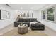 Comfortable living room featuring a gray sofa, round coffee table, and view into the kitchen at 10778 Haverstick Rd, Carmel, IN 46033
