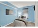 Bright bedroom with blue walls, modern art, and neutral decor, ideal for a restful retreat at 1099 Saratoga Cir, Carmel, IN 46280