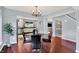Bright dining room boasts a modern chandelier and sleek black dining chairs around a dark marble table at 1099 Saratoga Cir, Carmel, IN 46280