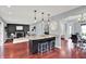View of kitchen island with seating, opens to living room with fireplace and dining area at 1099 Saratoga Cir, Carmel, IN 46280