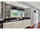 Wet bar boasts black and white tile backsplash, black counter tops and white cabinetry at 1099 Saratoga Cir, Carmel, IN 46280