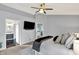 Bright main bedroom featuring a ceiling fan, television, and ensuite bathroom at 1099 Saratoga Cir, Carmel, IN 46280
