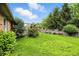 A lush green backyard featuring a fire pit, well-maintained lawn, bushes, and a wooden fence at 1106 Summer Way Ct, Shelbyville, IN 46176