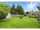 A spacious backyard with a lush lawn, mature trees, a storage shed and a quaint wooden frame deck at 1106 Summer Way Ct, Shelbyville, IN 46176